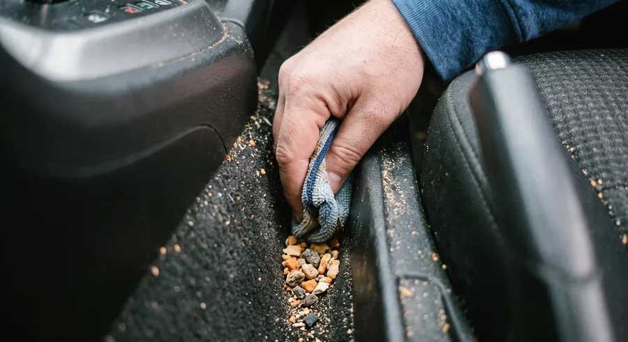 Migalhas e pequenos resíduos presos entre os bancos do carro